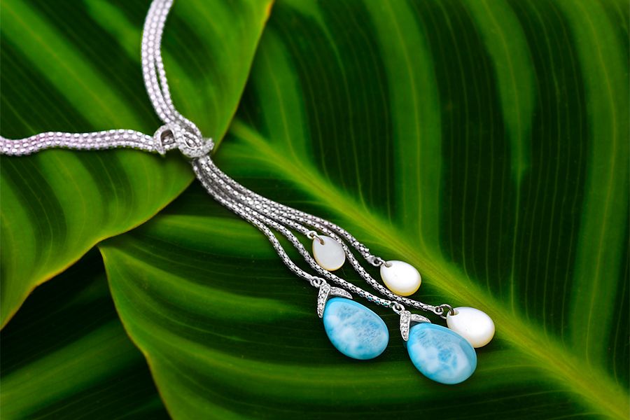 The Marahlago Enigma Larimar necklace is displayed on a green leaf.