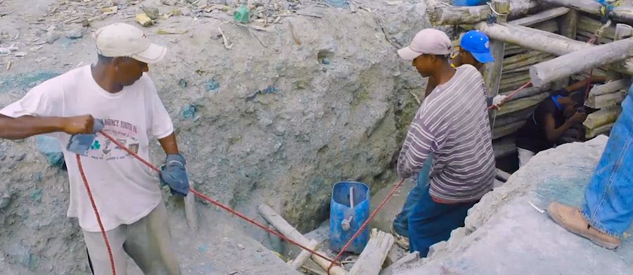 Workers are carrying raw Larimar stones out of the mine. Larimar mine work has to be done by hand.