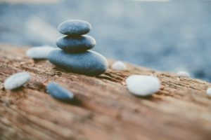 spirit rocks stacked on a log at the beach 2022 11 02 19 22 46 utc scaled e1682637347794