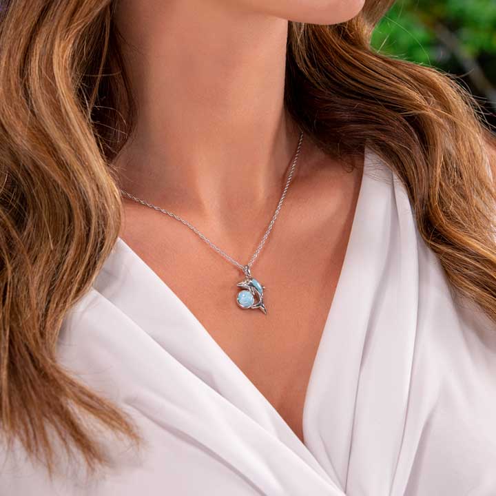Dive into elegance with Marahlago's Larimar Sterling Silver Dolphin Pendant Necklace. Adorned with shimmering white topaz gemstones, this silver blue jewelry piece is perfect for women seeking sophistication and a touch of marine-inspired beauty.